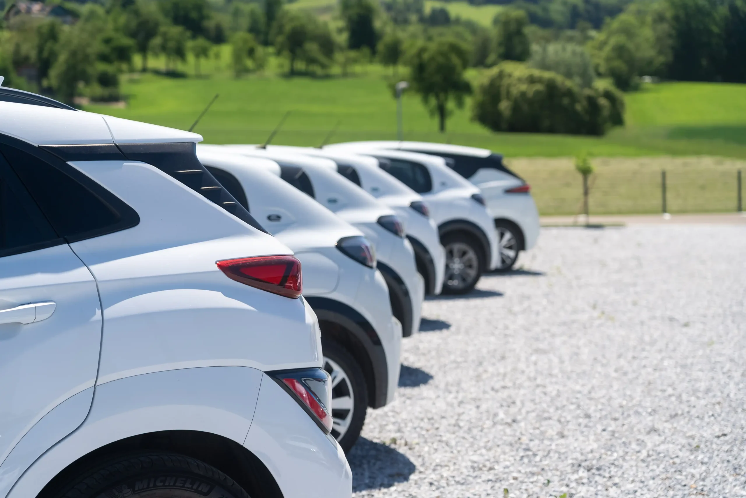 Eine Reihe geparkter weisser Fahrzeuge des Autohauses Comandella.