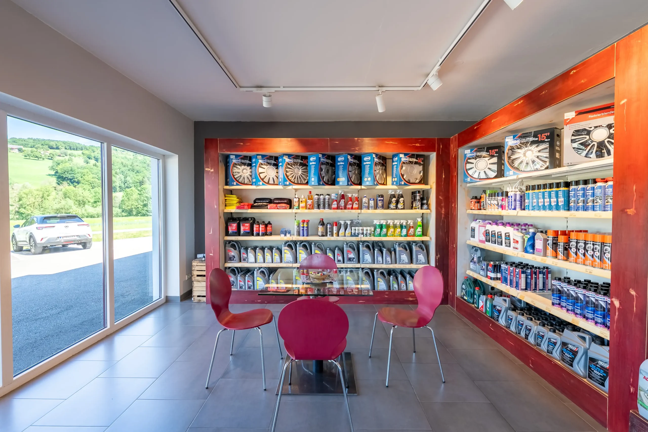 Innenansicht des Besprechungs- und Verkaufsbereichs des Autohaus Comandella mit diversen Autozubehoer Artikeln.