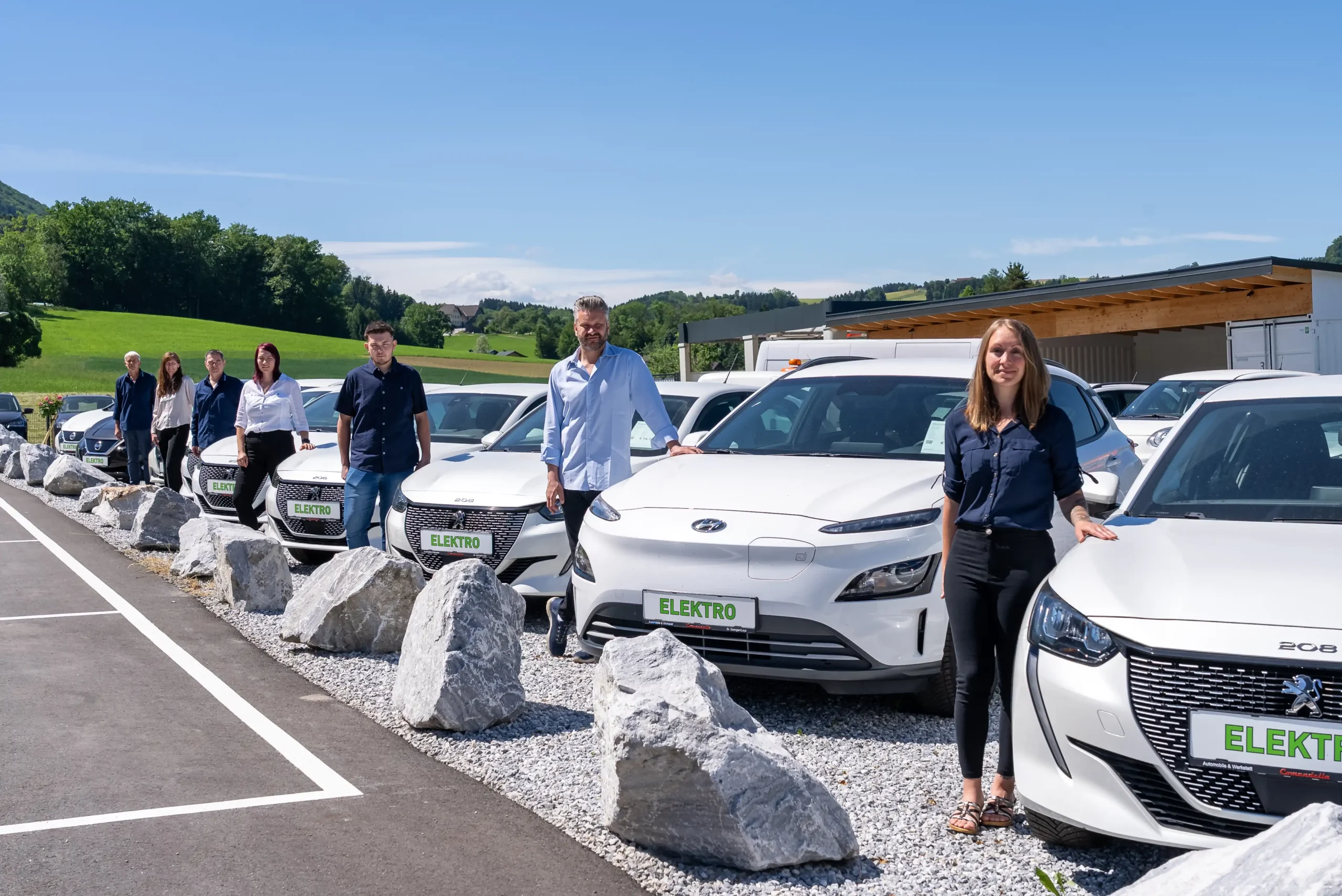 Das Team des Autohauses Comandella neben dem Fahrzeugbestand am Standort in St. Georgen an der Leys.